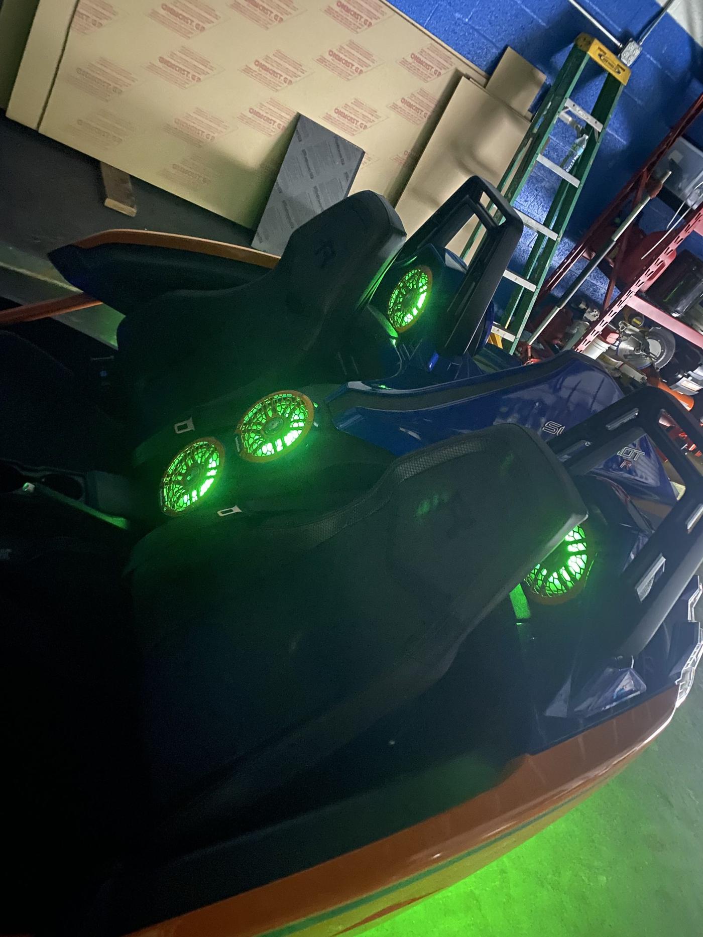 Boat glowing green at night from LED speaker rings