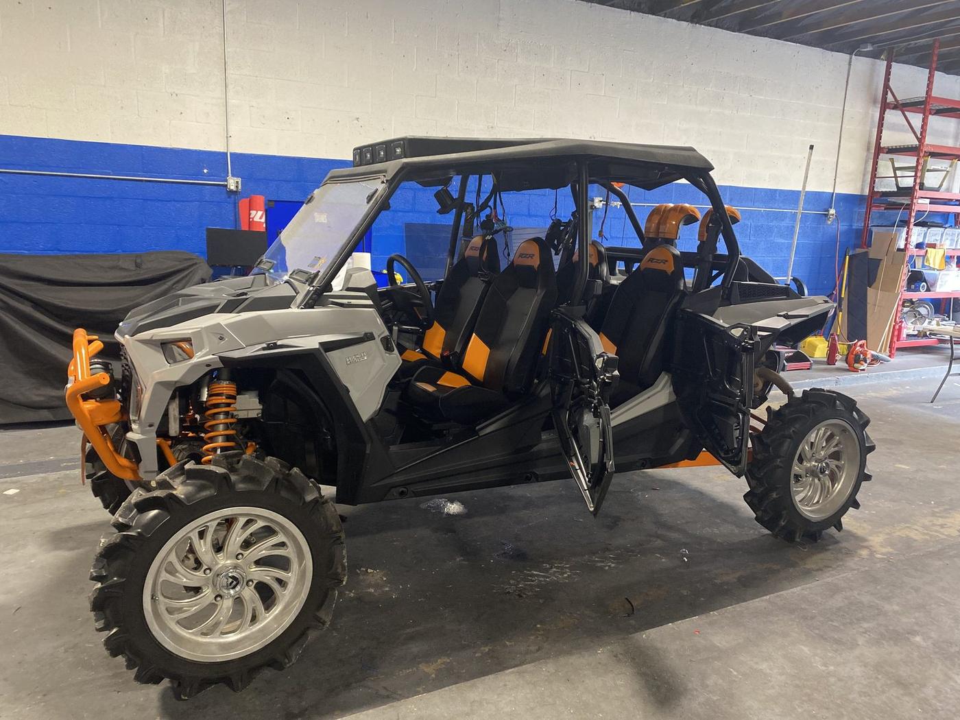 White and orange Polaris RZR in the shop