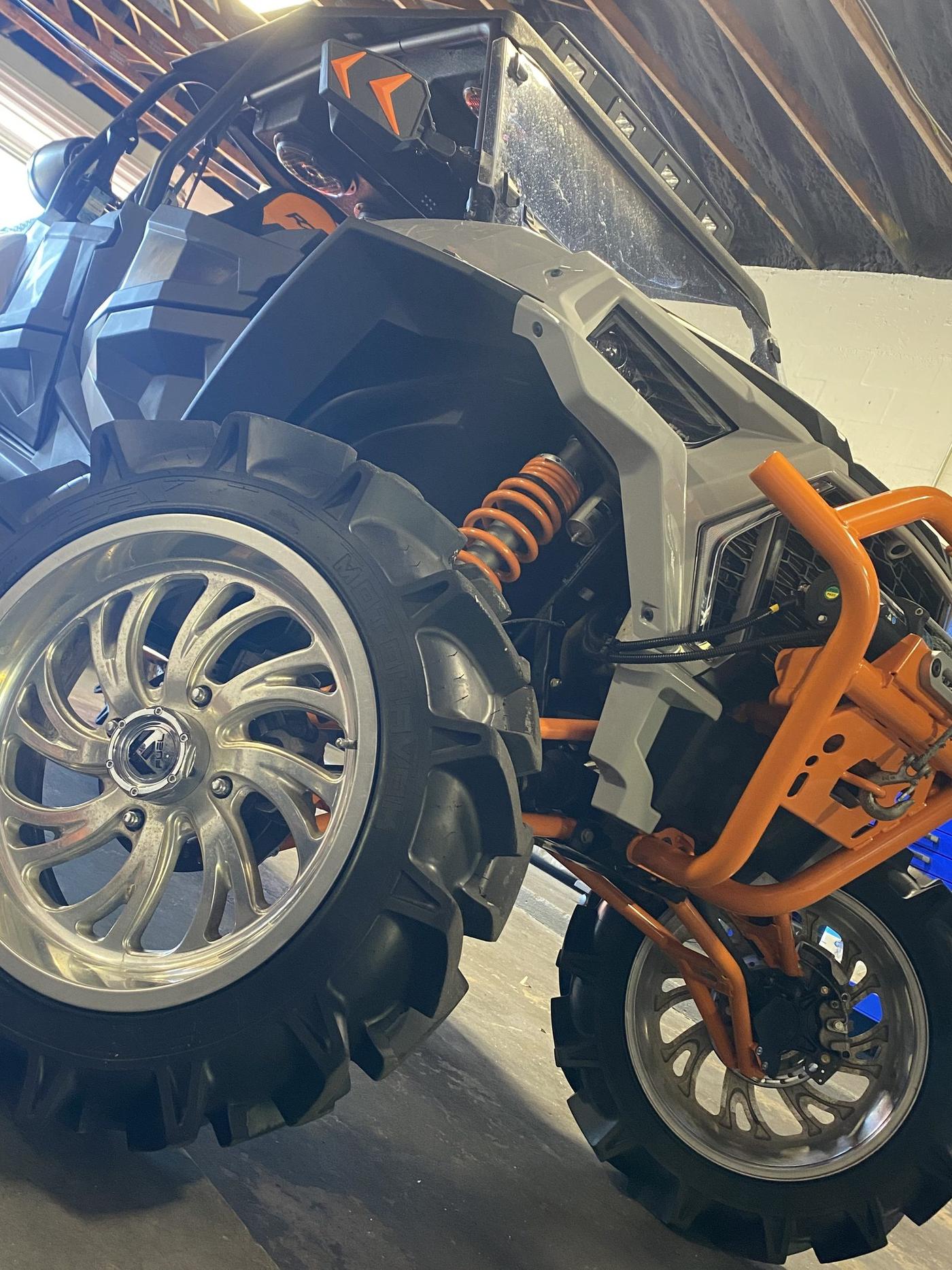 Custom UTV wheel and orange suspension detail